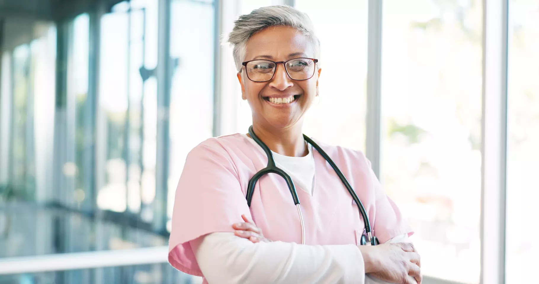 physician with arms crossed smiling